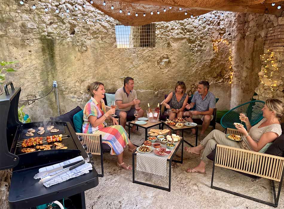 Apéritif entre amis le soir autour de la plancha à disposition dans le jardin.